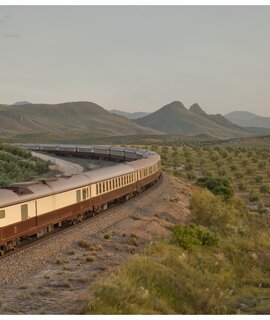 Der El Tren al Andalus auf den Schienen in einer grünen Steppenlandschaft in Andalusien. | ©  1999 Adobe Systems Incoporated/Renfe