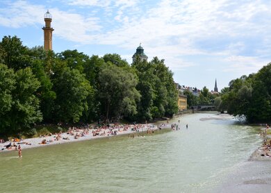 Strand an der Isar in München, Menschen liegen auf dem Kiesstrand | © Gettyimages.com/gionnixxx